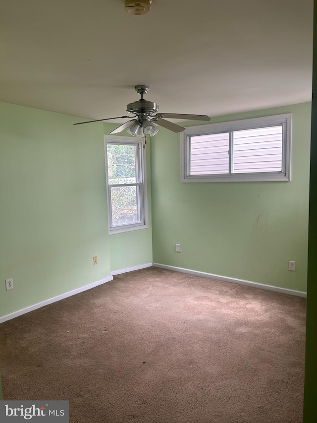 unfurnished room with ceiling fan and carpet