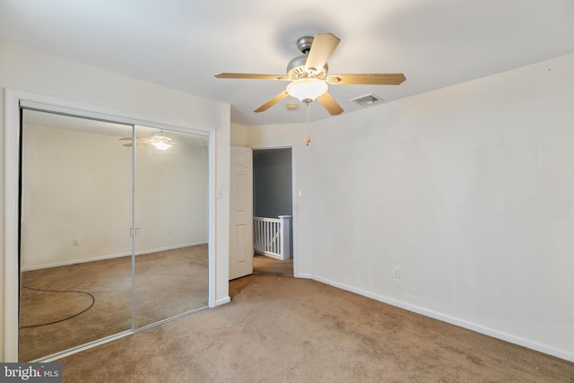 unfurnished bedroom featuring light carpet, ceiling fan, and a closet