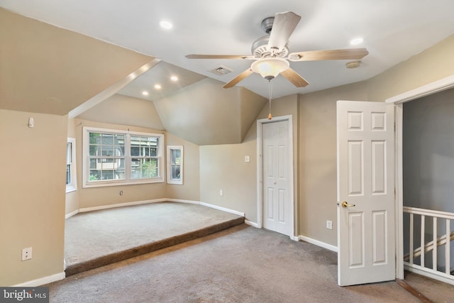 interior space featuring lofted ceiling, ceiling fan, and carpet floors