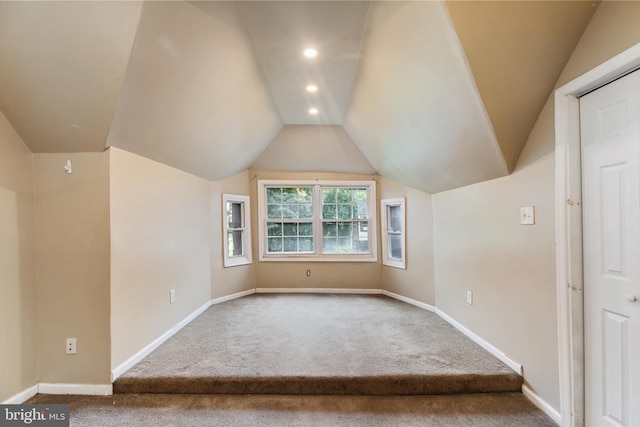 bonus room with vaulted ceiling and carpet flooring