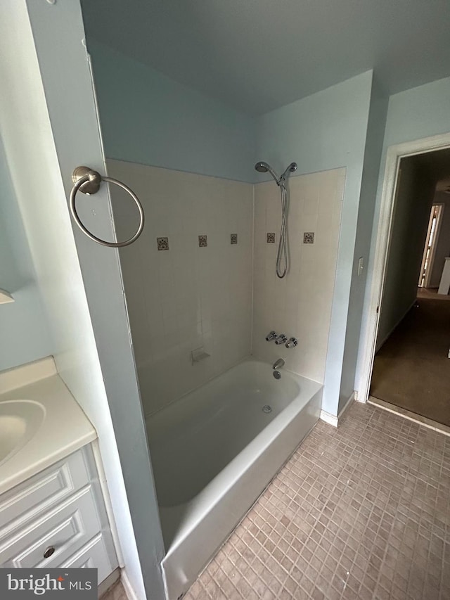 bathroom with tile patterned flooring, vanity, and tiled shower / bath