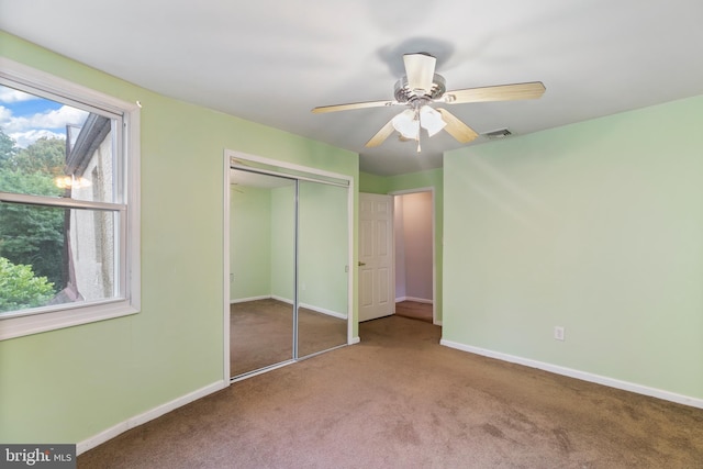 unfurnished bedroom with a closet, ceiling fan, and carpet floors