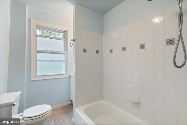 bathroom with tiled shower / bath combo, toilet, and tile patterned floors