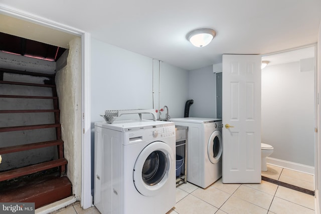 laundry area with light tile patterned floors and washer and dryer