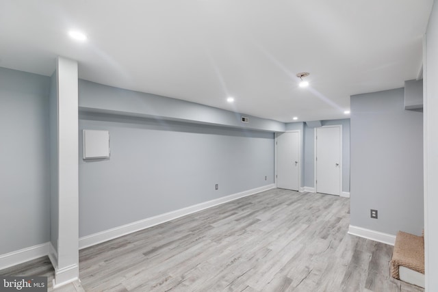 basement with light hardwood / wood-style flooring