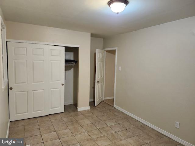 unfurnished bedroom featuring a closet and light tile patterned flooring