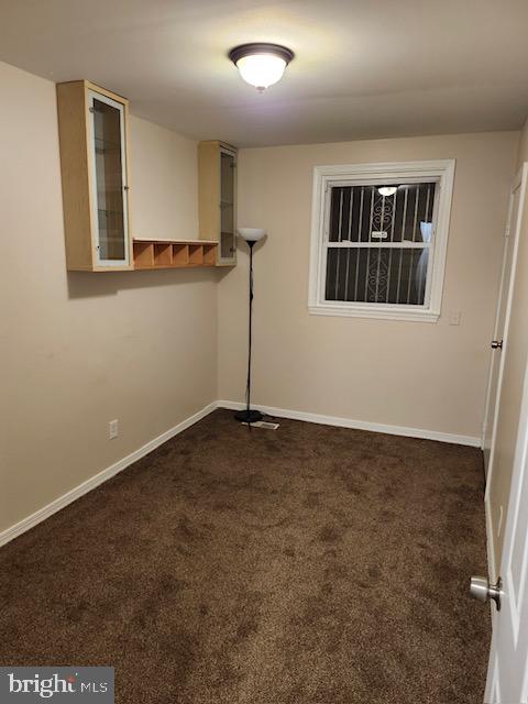 unfurnished room with dark colored carpet