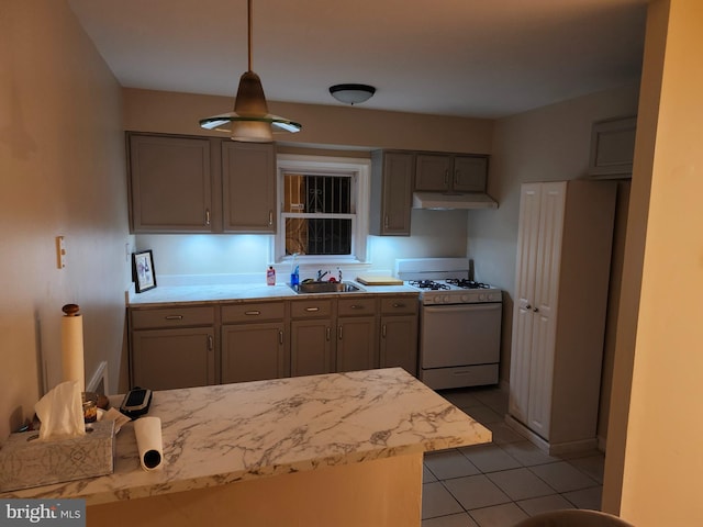 kitchen with pendant lighting, light tile patterned flooring, sink, gray cabinetry, and white gas range