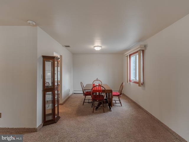 dining area featuring a baseboard heating unit and carpet floors