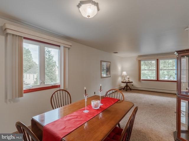 carpeted dining space with a baseboard heating unit and a healthy amount of sunlight