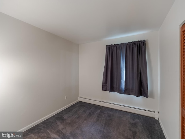 carpeted spare room featuring baseboard heating