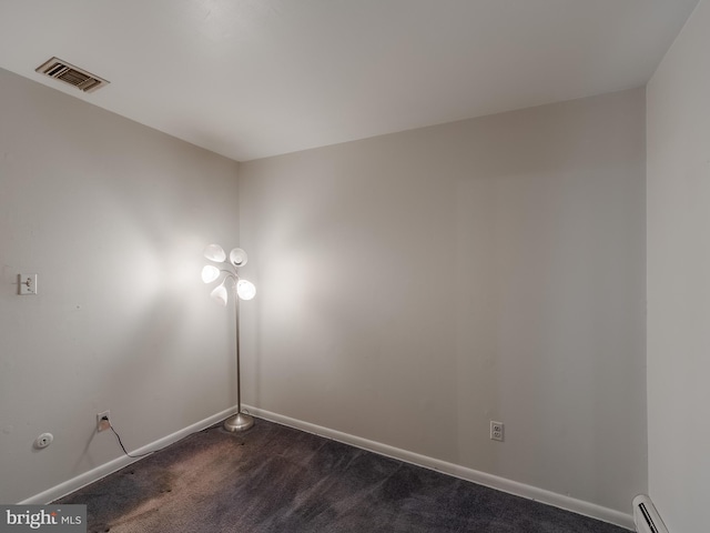 carpeted empty room with a baseboard radiator