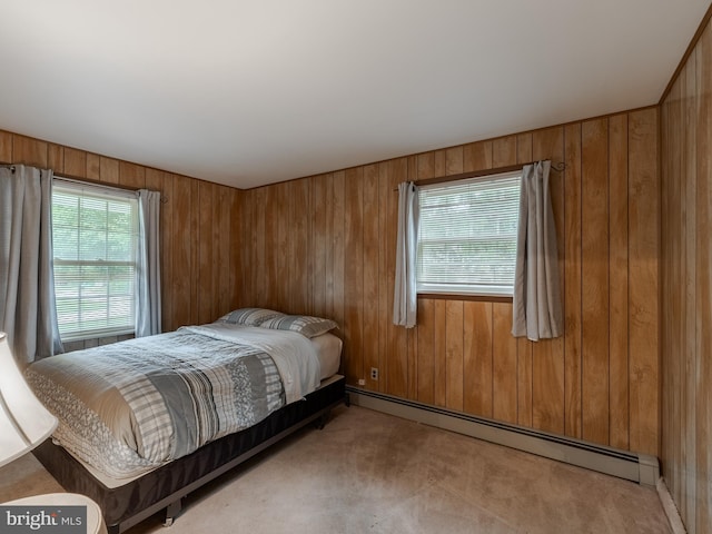 carpeted bedroom featuring wooden walls and baseboard heating