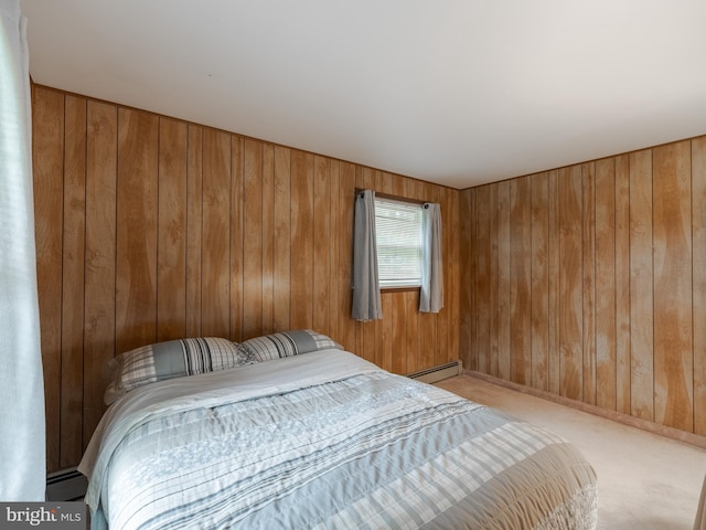 carpeted bedroom featuring wooden walls and baseboard heating