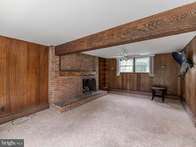 unfurnished living room featuring carpet floors, wooden walls, and a brick fireplace