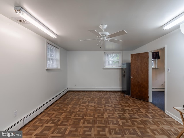 basement featuring dark parquet floors, ceiling fan, and a baseboard radiator