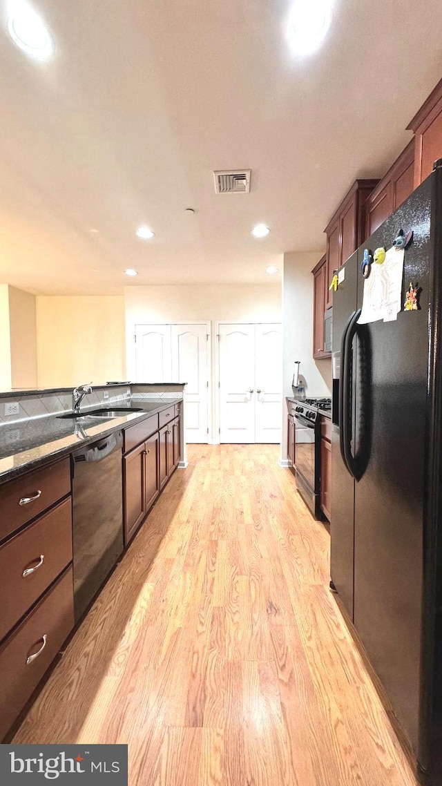 kitchen featuring sink, black appliances, and light hardwood / wood-style floors