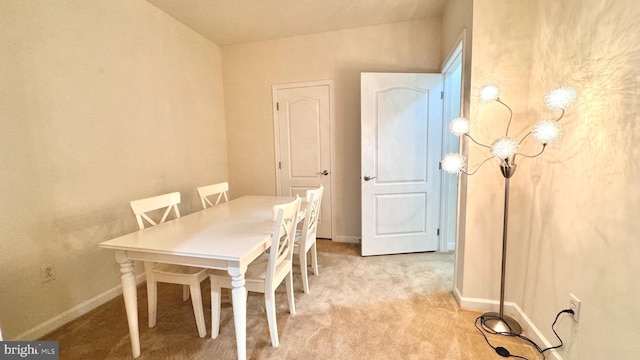 dining space featuring light carpet and vaulted ceiling