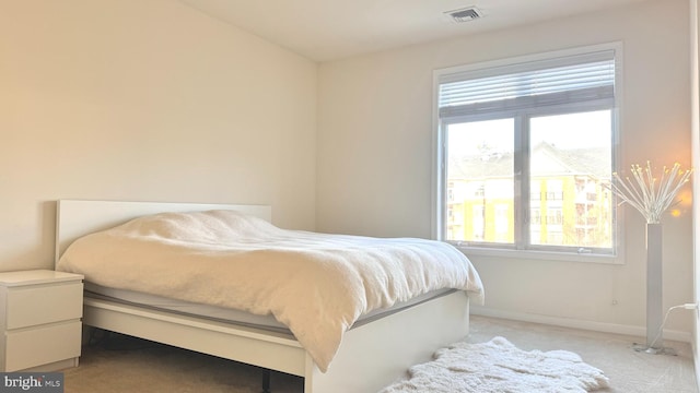 bedroom with multiple windows and light colored carpet