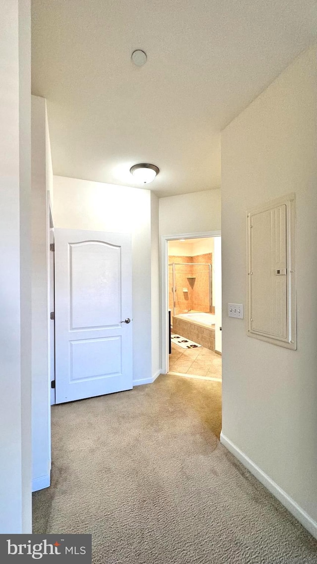 hallway with light carpet and electric panel