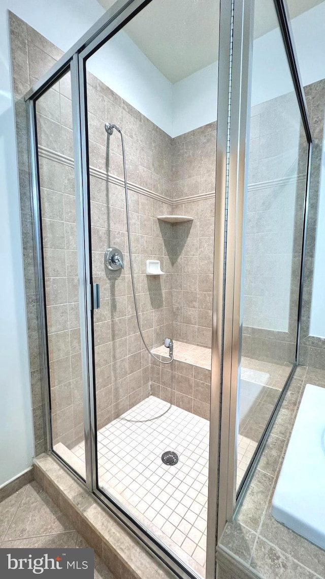 bathroom featuring a shower with door