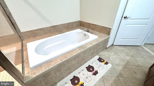 bathroom featuring tile patterned floors and a relaxing tiled tub