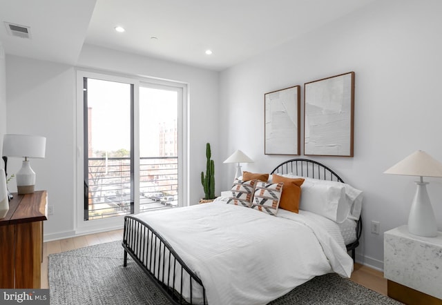 bedroom with wood-type flooring and multiple windows