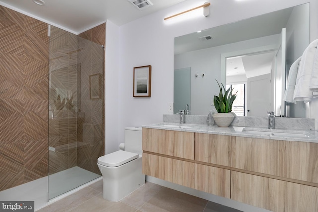 bathroom with tiled shower, vanity, toilet, and tile patterned floors