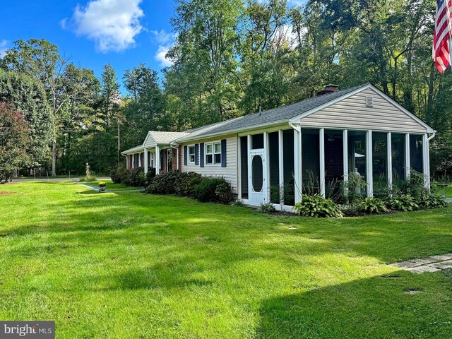 exterior space featuring a lawn and a sunroom