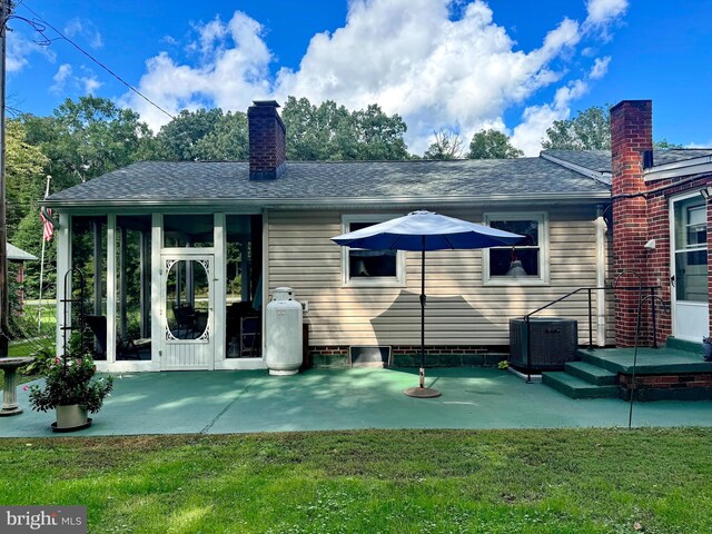 back of house with cooling unit, a lawn, and a patio area