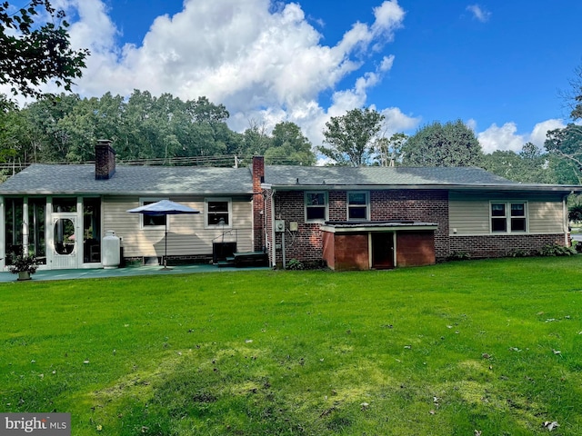 rear view of house with a lawn and a patio area