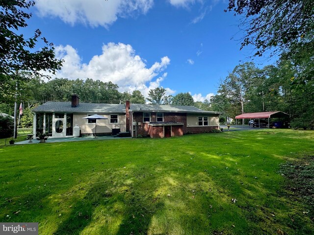 back of house with a lawn and a patio