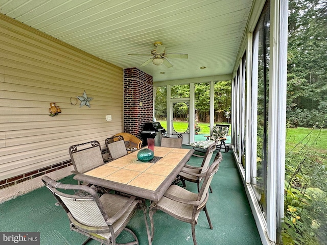 unfurnished sunroom with ceiling fan