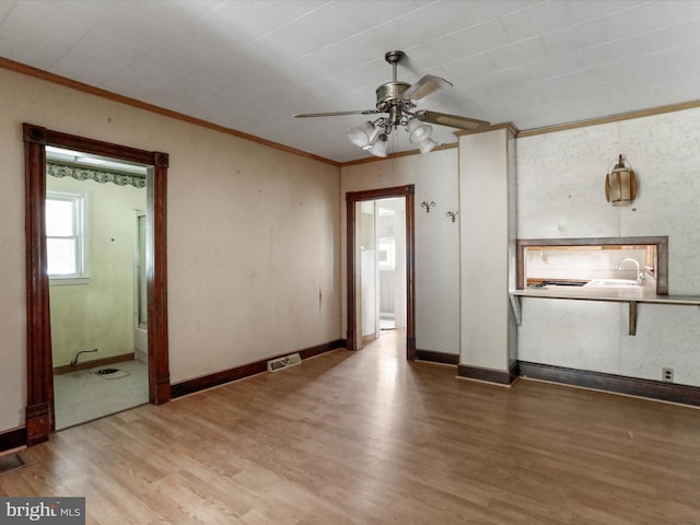 unfurnished room featuring crown molding, ceiling fan, hardwood / wood-style flooring, and sink