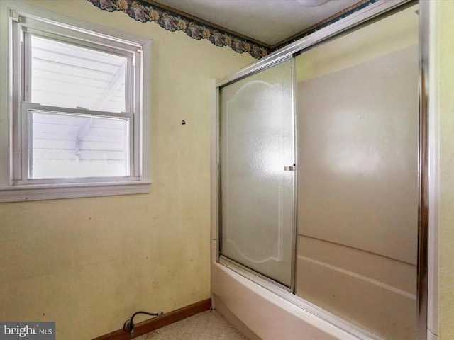 bathroom featuring combined bath / shower with glass door