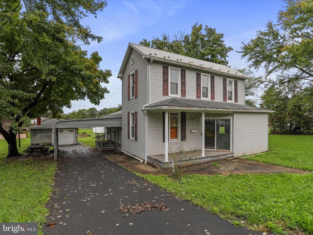 view of property featuring a front lawn, an outbuilding, and a garage