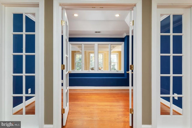 interior space with light wood-type flooring and crown molding