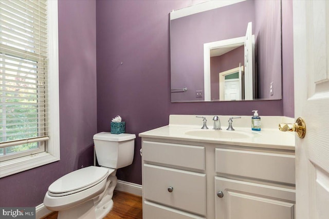 bathroom with hardwood / wood-style floors, vanity, and toilet