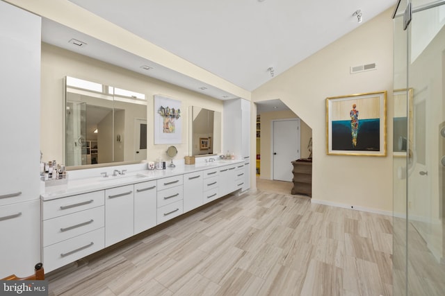 bathroom with vanity and vaulted ceiling