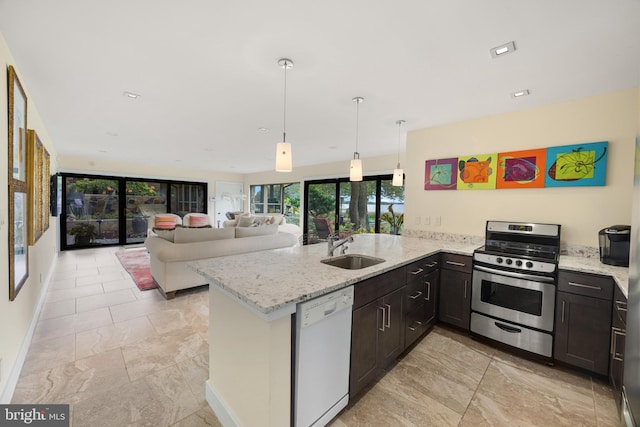 kitchen with dishwasher, sink, gas range, light stone counters, and kitchen peninsula