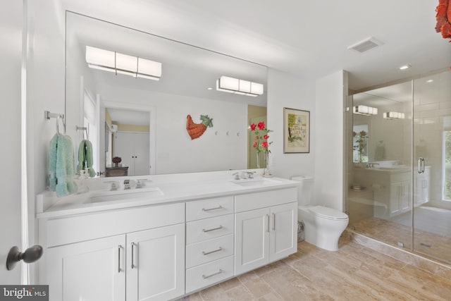 bathroom featuring hardwood / wood-style flooring, vanity, toilet, and walk in shower