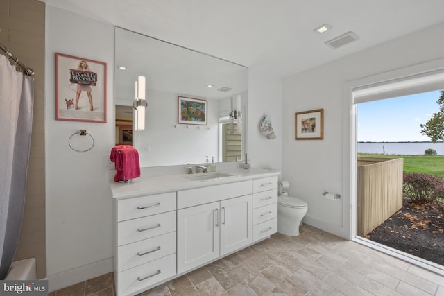 bathroom featuring curtained shower, vanity, and toilet