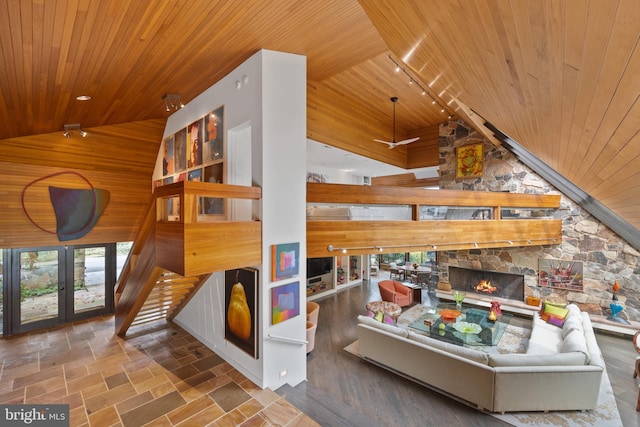 interior space with a healthy amount of sunlight, wooden walls, high vaulted ceiling, and wooden ceiling