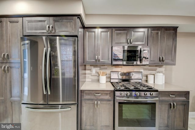 kitchen with dark brown cabinets, appliances with stainless steel finishes, and decorative backsplash