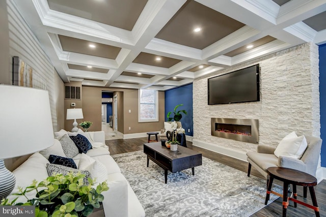 living room featuring ornamental molding, beam ceiling, a stone fireplace, coffered ceiling, and hardwood / wood-style floors