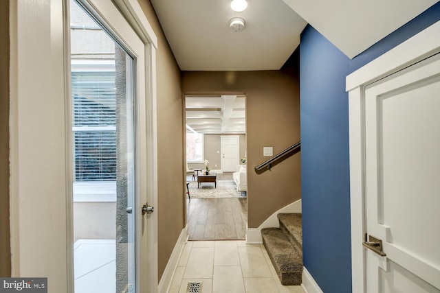 hall with light hardwood / wood-style floors and beam ceiling