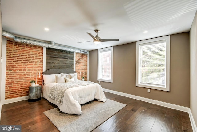 bedroom featuring dark hardwood / wood-style floors, ceiling fan, and brick wall