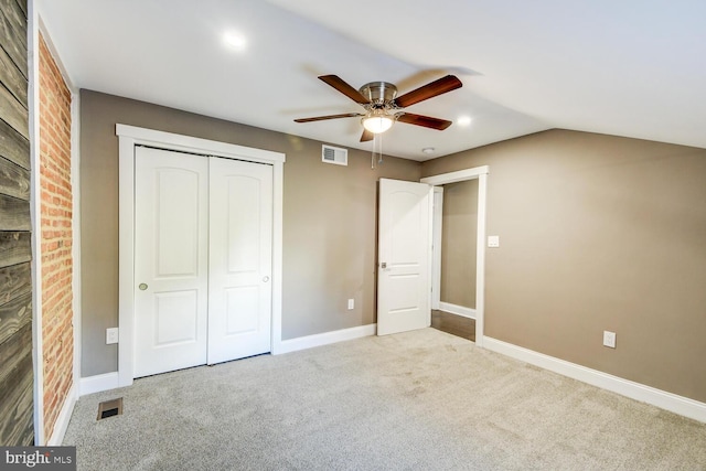 unfurnished bedroom with a closet, lofted ceiling, ceiling fan, and light colored carpet