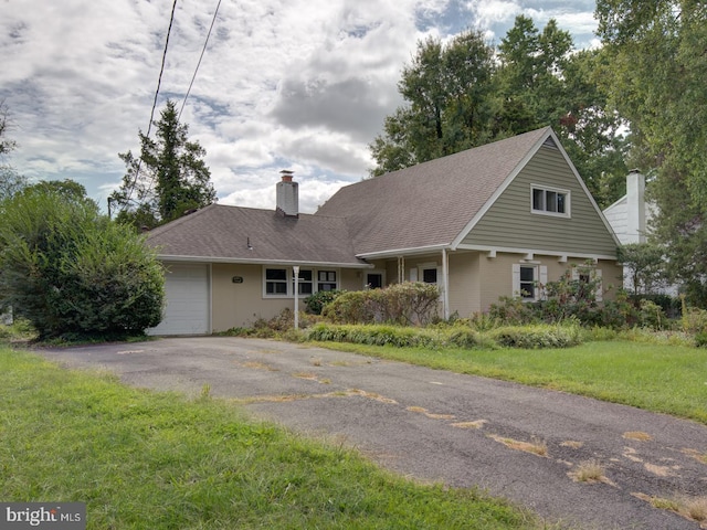 view of front of home with a front yard and a garage