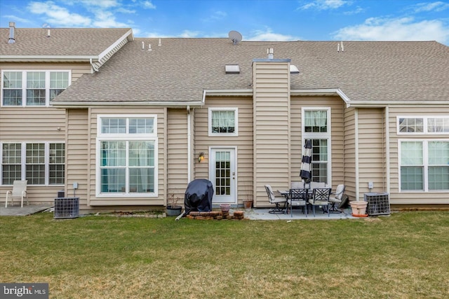 rear view of property featuring a lawn, a patio, and central AC